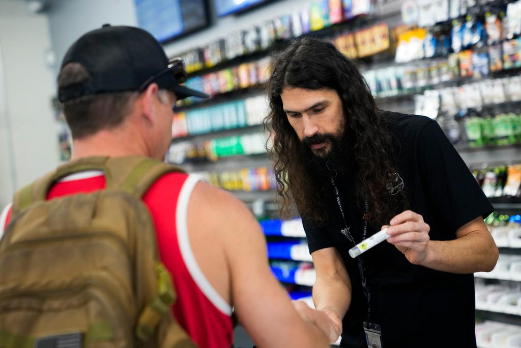 Cloud 9 Cannabis employee Beau McQueen, right, helps a customer, Saturday, April 13, 2024, in Arlington, Wash. The shop is one of the first dispensaries to open under the Washington Liquor and Cannabis Board's social equity program